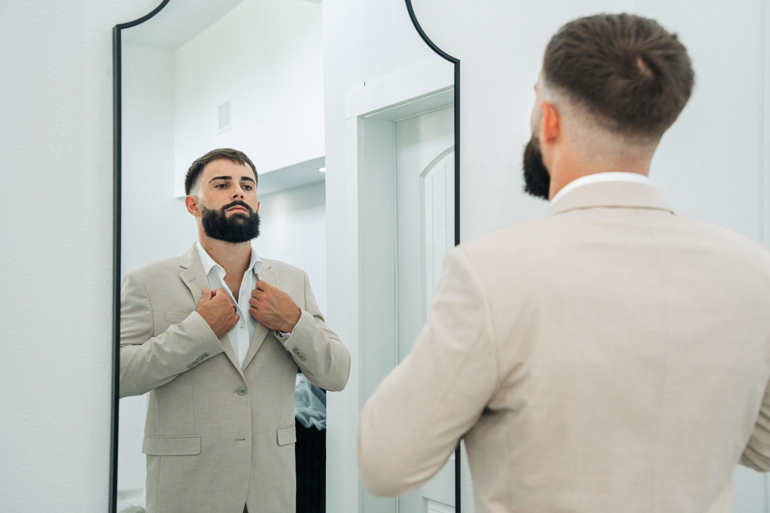 Bride and groom kissing under a rustic outdoor ceremony arch decorated